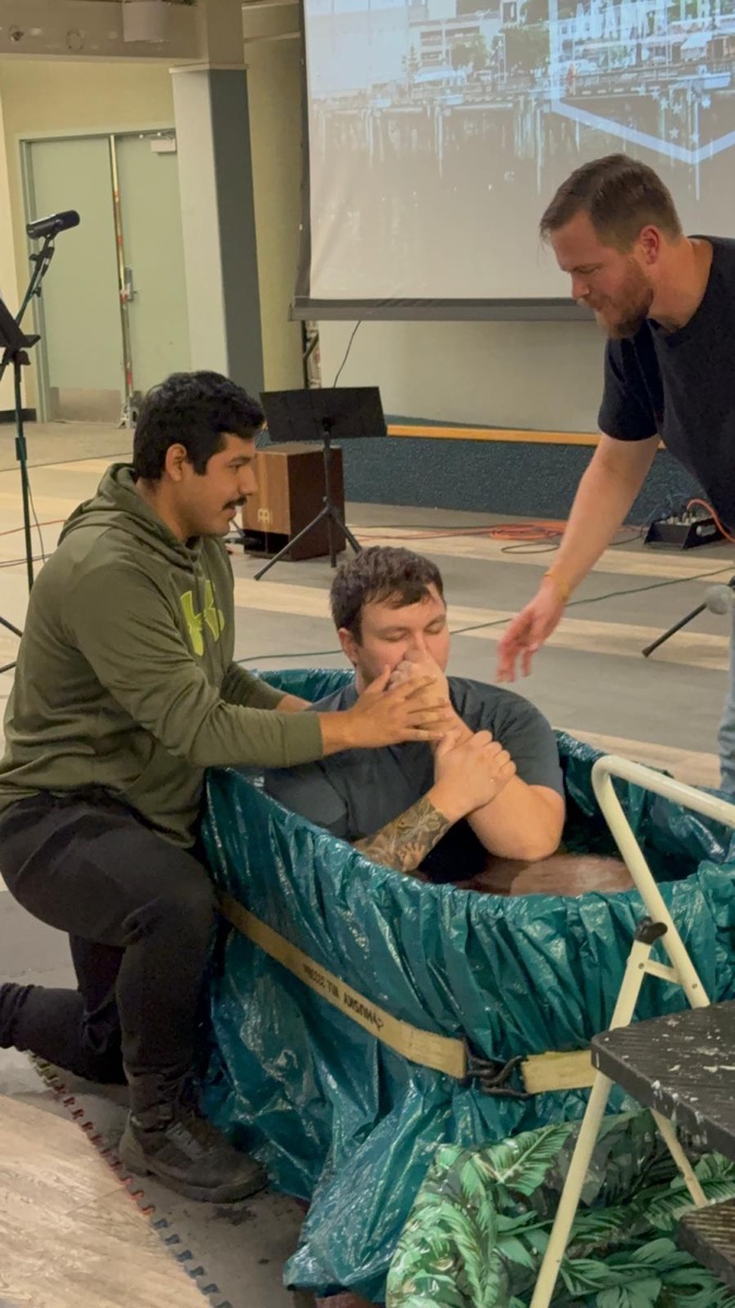 A student being baptized at a Chi Alpha gathering